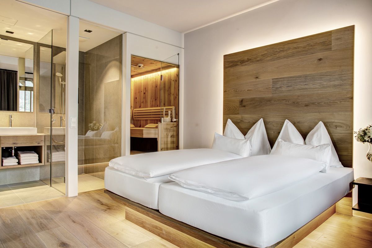 Modernt hotellrum i Seehotel Bellevue, angränsande öppet badrum med glasdusch och privat bastu
